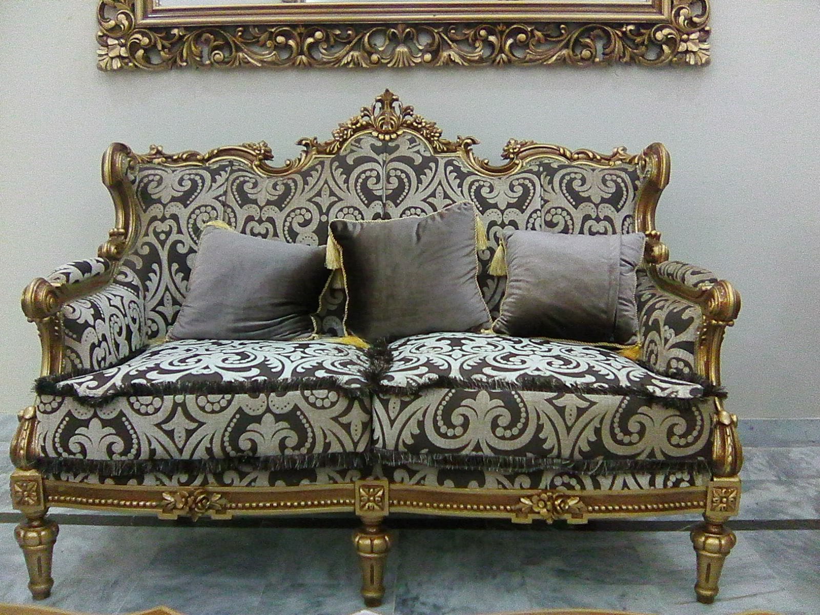 Front view of the carved gilded sofa with damask upholstery