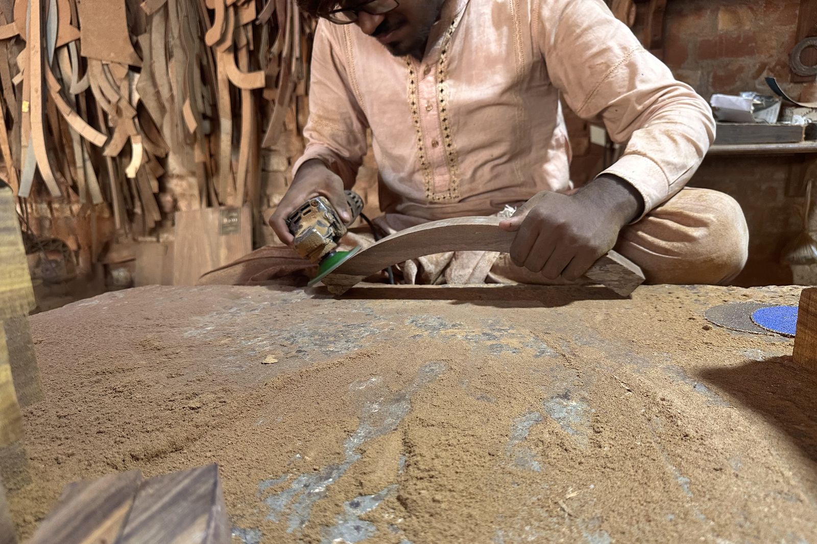 Hands sanding a curved wooden frame part