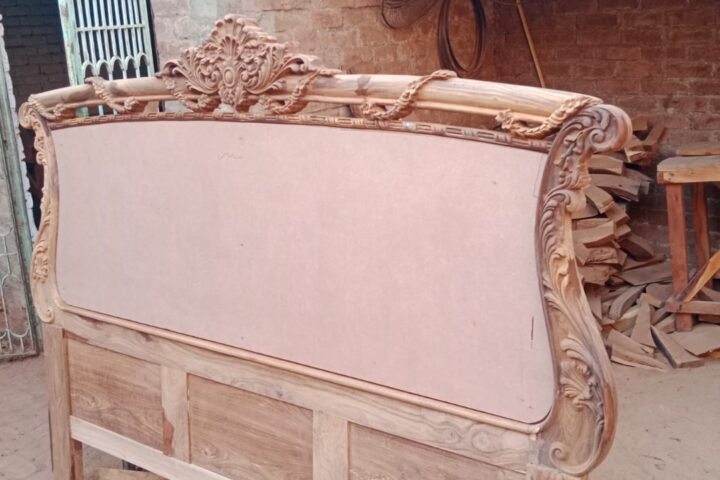 Rose-carved bed — headboard in the workshop