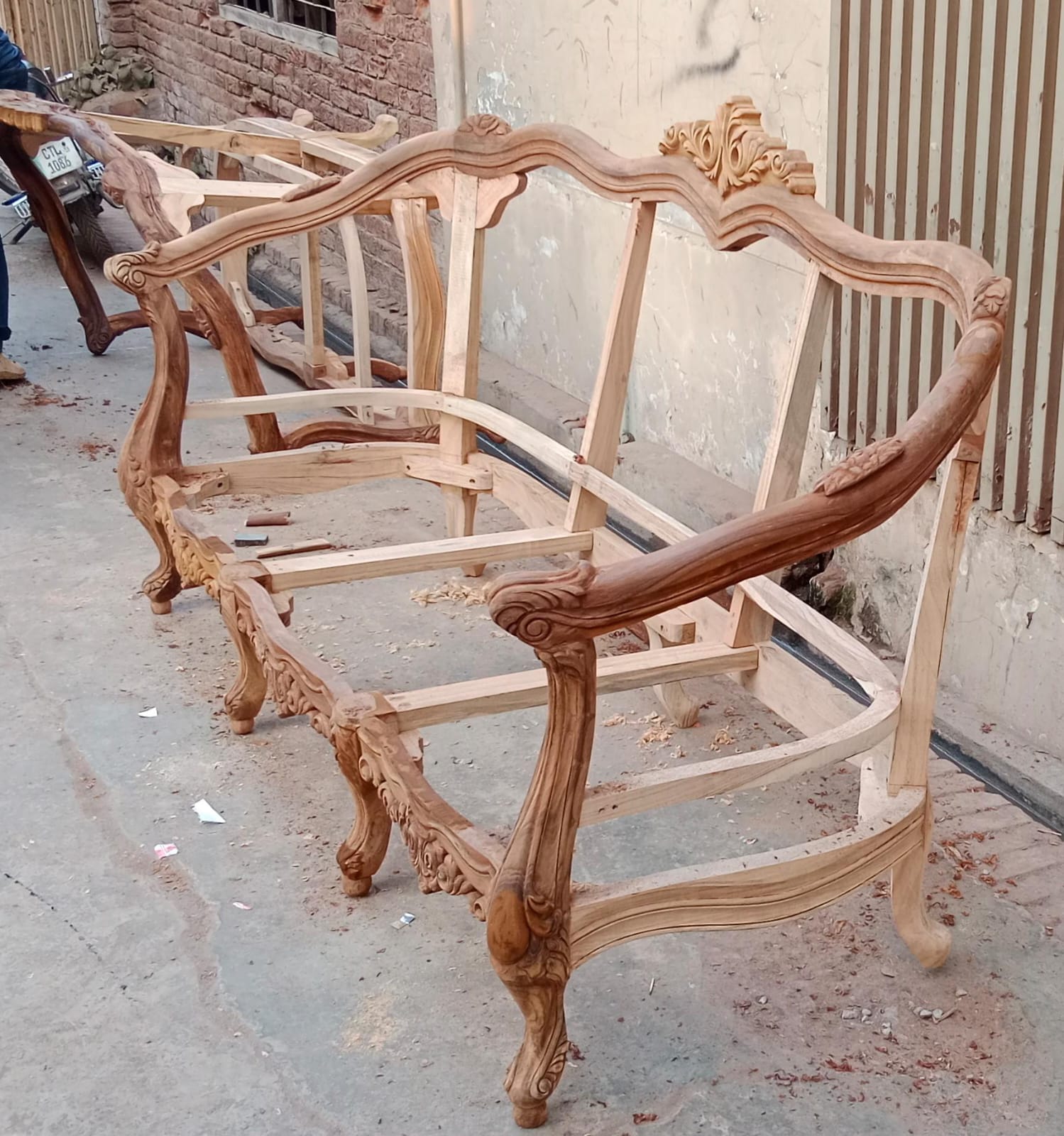 Crest-carved sofa — workshop photo, side view